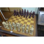 A resin chess set on chess table (on lot 914)
