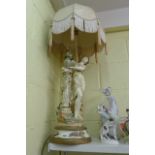 A large decorative table lamp and shade modelled as a Grecian maiden by a pillar with flowers. (S