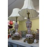 A pair of decorative white and cranberry overlay glass table lamps, enamelled with flowers, with