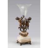 FLOWER VASE, EARLY 20TH CENTURY

burnished metal and gold with figures of angels. Cut glass tank,