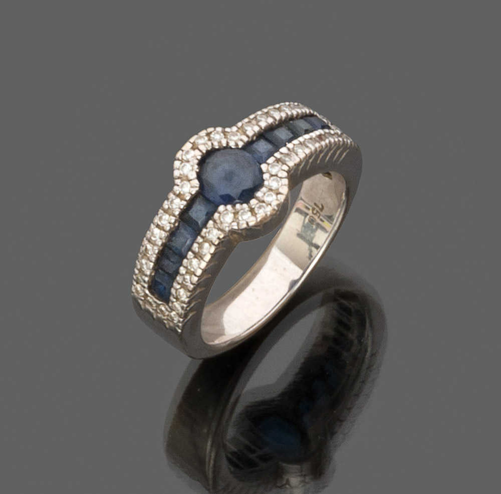 RING in white gold 18 kts., with pavè of sapphires to the center and small diamonds of contour.