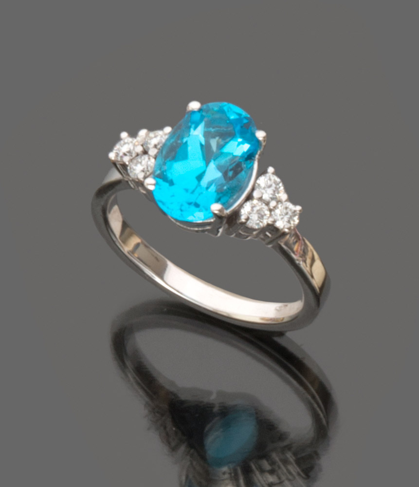 BEAUTIFUL RING in white gold 18 kts., with central topaz London and diamond of contour. Topaz ct.