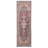 SMALL GALLERY KIRMAN CARPET, MID 20TH CENTURY with rich floral design in the central field a blue