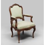WALNUT ARMCHAIR, NORTHERN ITALY 18TH CENTURY with moulded back and armrests, carved scrolls and