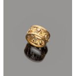 ANELLO a fascia in oro giallo 18 kt., traforata a motivi vegetali con decoro di sette brillanti.