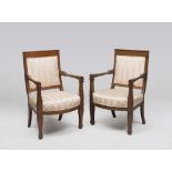 A PAIR OF WALNUT ARMCHAIRS, PERIOD OF THE CONSULATE to square back, tubular arms and uppercuts to