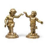 A PAIR OF GILDED WOOD SCULPTURES, 18TH CENTURY representing figures of children in laying. Rocks