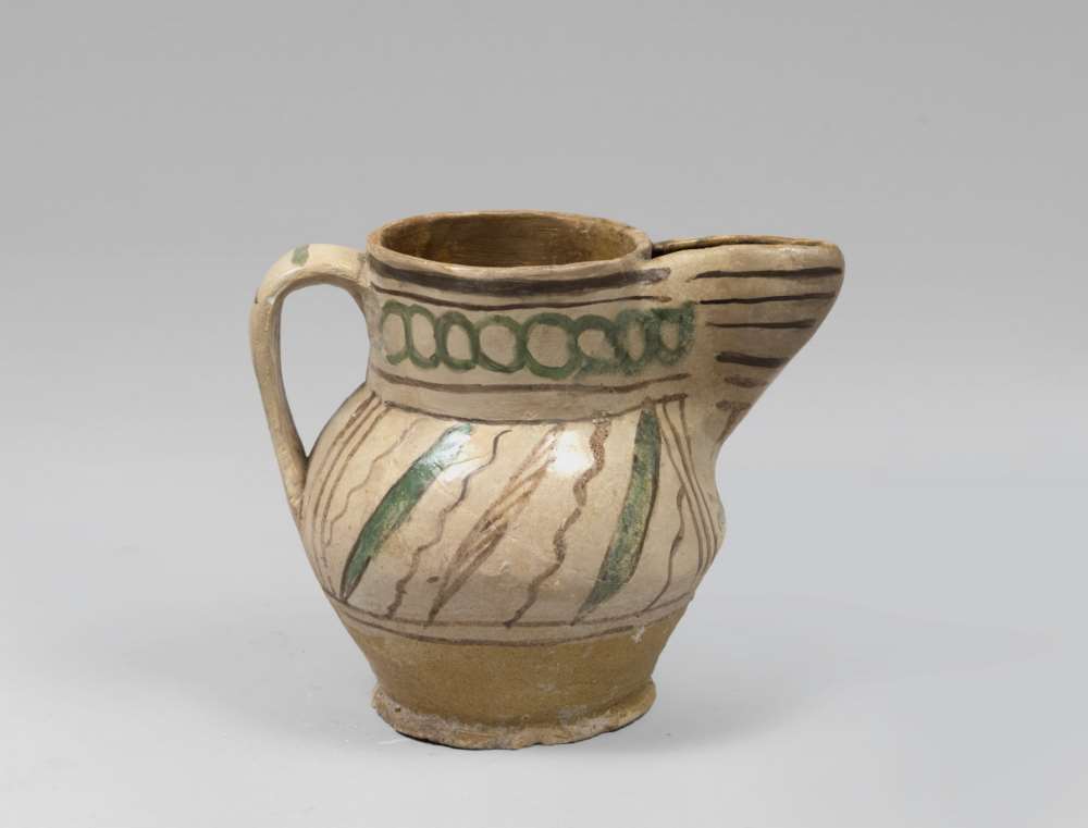 MAJOLICA PITCHER, VITERBO 16TH CENTURY with rests of decorums to brown and green enamel on beige