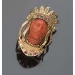 PIN in yellow gold 18 kts., with coral graven to figure of Indian and decorum with rubies and