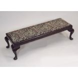 FOOTSTOOL. An upholstered long footstool on cabriole legs.