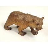 SWISS BEAR. A Swiss carved bear with black glass eyes. Length 10cm, height 6cm.