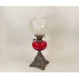 OIL LAMP. A Victorian oil lamp with red glass fount & cast iron base. Height 59cm.