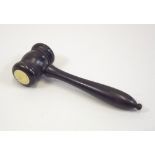 GAVEL. A late 19th century turned ebony gavel, one side of the head inset with ivory. Length 18cm.