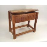 OAK STOOL. A 20th century carved oak lidded stool, in Cotswold style. Height 51cm. Width 56cm.