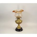 OIL LAMP. A Victorian brass oil lamp with frilled glass shade. Height 55cm.