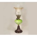 OIL LAMP. A Victorian oil lamp with green tinted glass fount & cast iron base. Height 62cm.