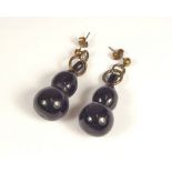 AMBER. A pair of black amber gourd shaped pendant earrings.