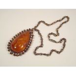 AMBER. A silver coloured metal necklace, set a large amber drop.