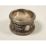 CHINESE NAPKIN RING. A Chinese silver coloured metal napkin ring with pierced overlay.