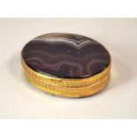 AGATE BOX. A 19th century banded agate box with gilt metal mounts. 5.5 x 4.5cm.