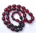 Amber colour bead necklace with thirty eight graduated beads, the longest approx 2cm wide, knotted