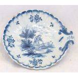 Delft blue and white scallop shape pickle dish, painted with rural tableau of young man playing a