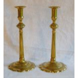 Pair of George II brass candlesticks with fixed nozzles, on tapered circular stems and petal