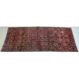 A Baluchi runner with red ground, the open field decorated with five rows of fifteen guls,