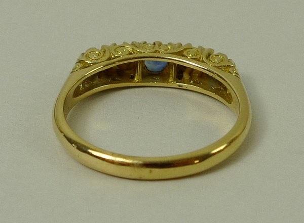 An 18ct gold, sapphire and diamond ring, set with three sapphires divided by two diamonds accents, - Image 3 of 3