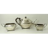 An Edwardian three piece silver tea set, of oblong form with canted corner,