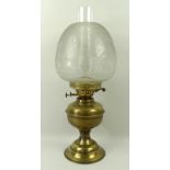 A brass oil lamp with a clear etched glass shade and double burner, 48cm.