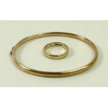 A 9ct gold hoop bangle, together with a 9ct gold wedding band, size M, 7.6g total weight.
