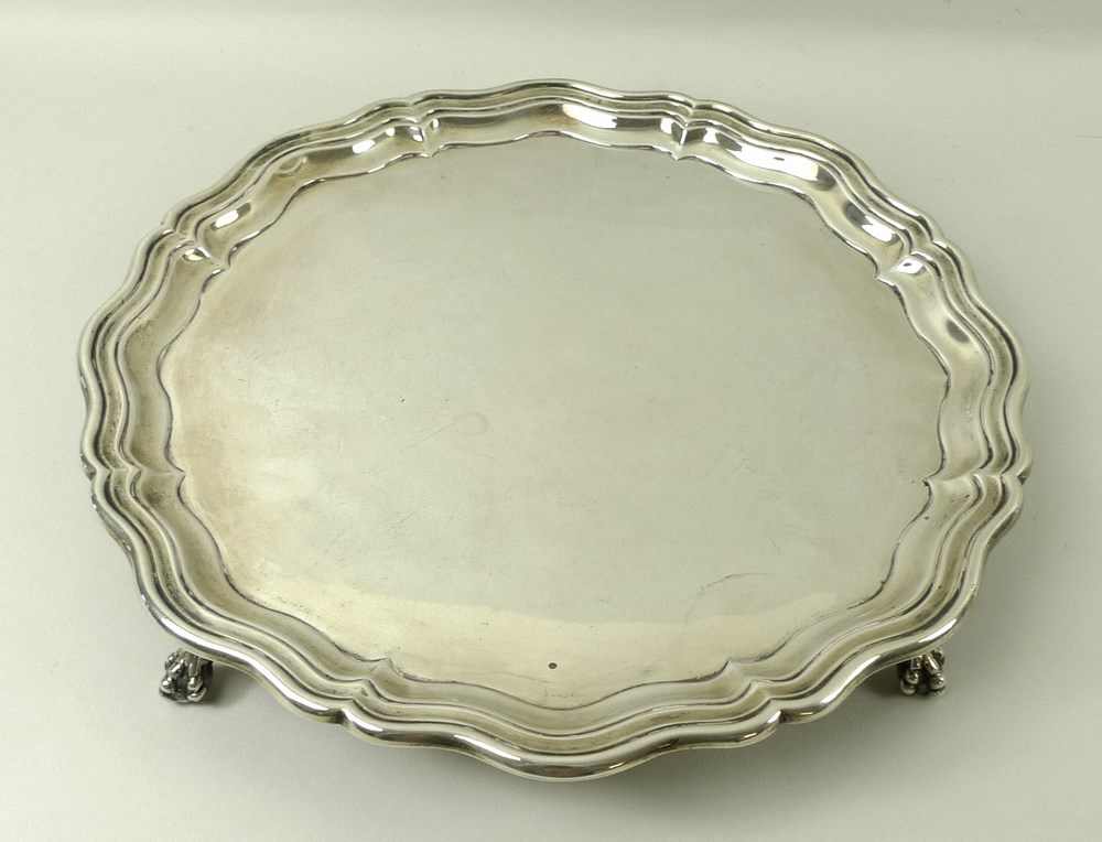 A silver salver, Chippendale piecrust edge, raised on four ball and claw feet, Sheffield 1924,