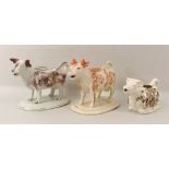 A group of three Staffordshire cow creamers,