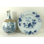 An English Delftware plate, 18th century, the blue ground decorated with a central flower and tree,