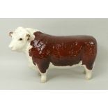 A Beswick figurine of a Hereford Bull, marked to underside 'Ch. of Champions', 19 by 11cm.