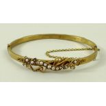A 15ct yellow gold and natural seed pearl bangle, with trefoil and scroll motif, 12.