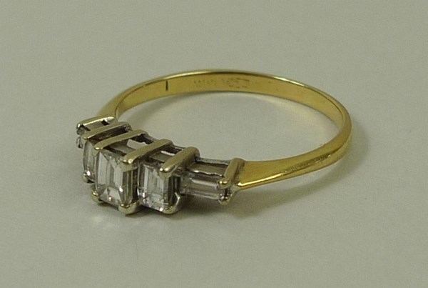 A gold and diamond ring, the central baguette cut diamond flanked by two smaller diamonds, - Image 2 of 3