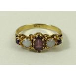 A 15ct gold, amethyst and opal ring, the central oval cut amethyst flanked by two opals,