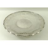 A silver circular cake plate, fret cut band and applied cast rim, raised on a circular foot,