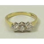 An 18ct gold and diamond three stone ring, the central diamond of approximately 0.25ct, with 0.