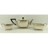 An Art Deco silver three piece tea service of oblong form with incuse corners,