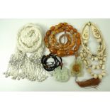 A collection of costume jewellery comprising two jade pendants, a bone necklace,
