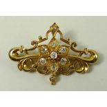 A diamond and yellow metal brooch, the central flower set with seven diamonds, each approximately 0.