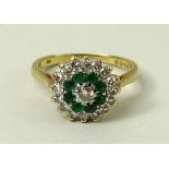 An 18ct gold, diamond and emerald cluster ring, the central diamond of approximately 0.