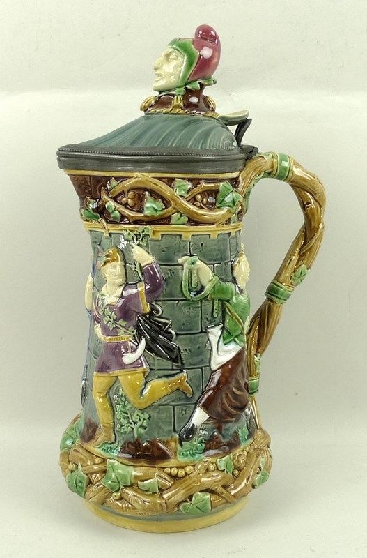 A Minton Majolica Jester tower jug, with moulded dancing figures,