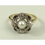 An 18ct gold and platinum set diamond and pearl ring, the central pearl, 4mm, with a 0.