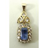 A 9ct gold and sapphire oval pendant in a surround of white sapphires on a white sapphire set