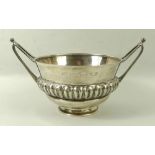 An Art and Crafts silver bowl, with repeating gadrooned ellipses and two stylised elongated handles,