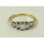 A gold and diamond ring, the central baguette cut diamond flanked by two smaller diamonds,